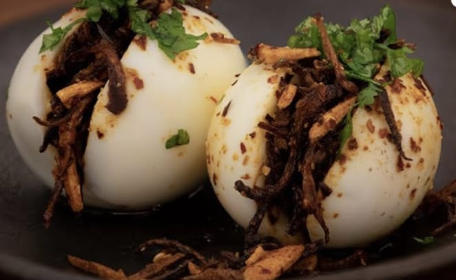 Perfectly boiled eggs topped with crispy fried onions and aromatic spices